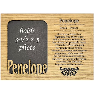 May include: A wooden frame with a black chalkboard insert that says "holds 3-1/2 x 5 photo" and "Penelope". The frame also has the name "Penelope" and the text "Greek - weaver" along with a description of the name's meaning.