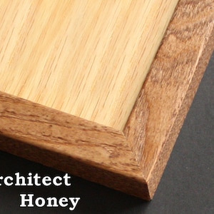 May include: Close-up of a wooden picture frame with a light wood interior and a darker wood exterior. The frame is labeled "Architect Honey".