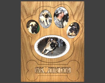 May include: Wooden photo frame shaped like a dog paw print with five oval openings for pictures. The frame has a bone-shaped base with the text "We love our dog" carved into it.
