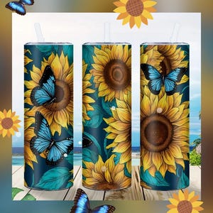 May include: Three tall, cylindrical tumblers with lids and straws. Each tumbler features a design of a yellow sunflower and a blue butterfly against a dark teal background. Additional butterflies and sunflowers are scattered around the tumblers.