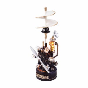 May include: Steampunk-style decorative lamp with a propeller, a white spiral, and a cylindrical light. The lamp has a black base with the word "ROKR" in gold lettering. The lamp is made of metal and glass.