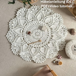 May include: A white, circular, crocheted doily with a detailed floral pattern. The doily is surrounded by small decorative items, including a wooden star, a small toy drum, and a plush sheep head.