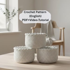 Könnte beinhalten: Drei weiße Häkelkörbe mit gewellten Kanten sind auf einem hellen Holztisch gestapelt. Die Körbe sind aus dickem Garn gefertigt, und die Textur ist sichtbar. Der Text auf dem Bild lautet "Crochet Pattern (English) PDF+Video-Tutorial."