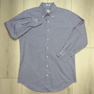 May include: A long-sleeved button-down shirt in a blue and white checkered pattern. The shirt has a button-down collar, a chest pocket, and buttoned cuffs. The shirt is made of a lightweight fabric and is suitable for casual wear.