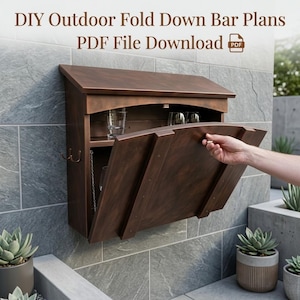 Puede incluir: Un bar plegable de madera marrón oscuro montado en la pared con techo inclinado, estantes interiores y ganchos laterales de metal. El texto dice: DIY Outdoor Fold Down Bar Plans PDF File Download. La unidad tiene un panel frontal abatible.