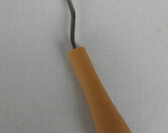 May include: A metal crochet hook with a brown plastic handle. The hook is curved and has a small loop at the end.