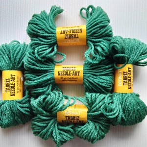 May include: Four skeins of emerald green Bernat Tabriz Needle Art yarn, each featuring a yellow paper label with black text stating 30 yd. Pull Skein and 100% Polyester. The yarn is thick, twisted, and arranged in a cluster on a white surface.