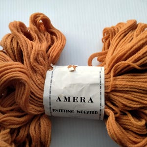 May include: A skein of brown knitting worsted yarn with a white label that reads "AMERA KNITTING WORSTED".