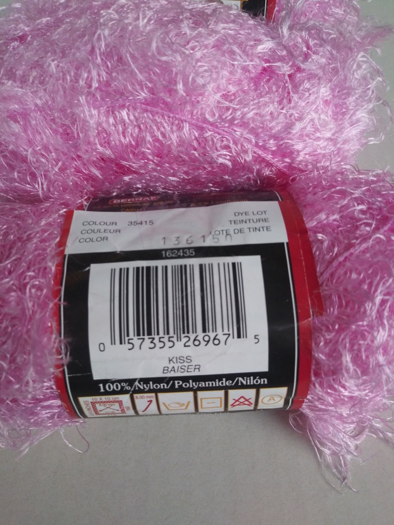 May include: A pink ball of yarn with a label that reads "Kiss Baiser" and "100% Nylon/Polyamide/Nil&oacute;n". The label also includes a barcode and the numbers "35415", "1361", and "162435".
