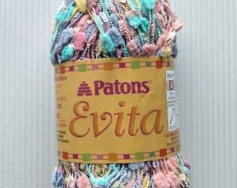 May include: A skein of Patons Evita yarn in a multi-colored mix of pink, blue, yellow, and green. The yarn is bulky and has a fuzzy texture. The label reads "Patons Evita" and includes information about the yarn's weight and care instructions.