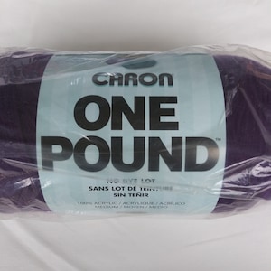 May include: A purple Caron One Pound yarn skein in a plastic bag. The label reads "CARON ONE POUND" and "NO DYE LOT SANS LOT DE TEINTURE SIN TEÑIR 100% ACRYLIC/ACRYLIQUE/ACRÍLICO MEDIUM/MOYEN/MEDIO".