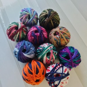 May include: Ten balls of yarn in various colors and patterns, including green, blue, red, orange, white, and purple.