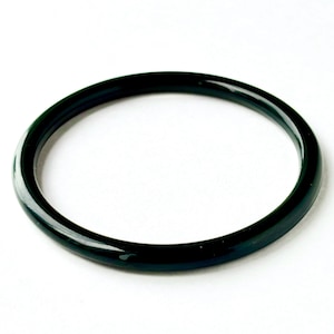 May include: A dark green bangle bracelet. The circular bracelet is a solid color with a glossy finish. The jewelry is set against a white background. The bangle is a simple, elegant accessory.