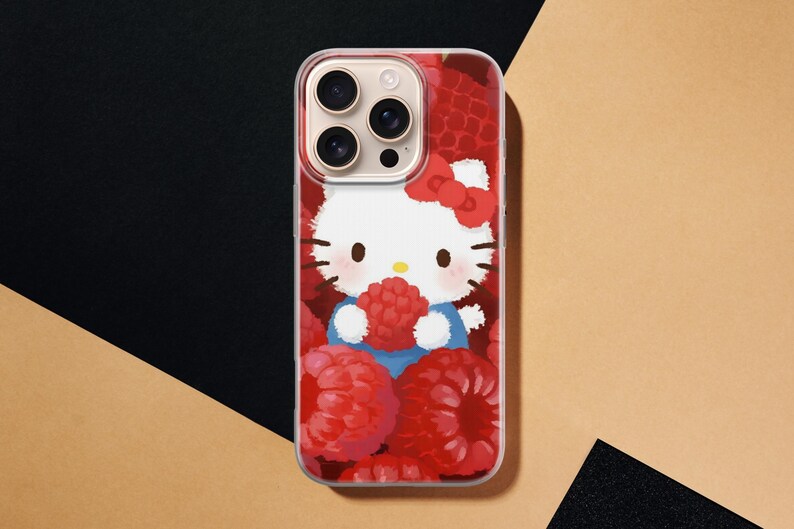 May include: A clear phone case featuring a cartoon image of Hello Kitty holding a raspberry. The design includes a red bow, blue clothing, and a background of red raspberries. The phone case is designed to fit a smartphone.