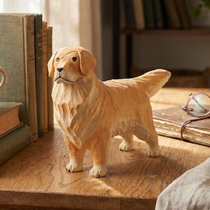 May include: A light brown, carved wooden figurine of a standing golden retriever dog. The sculpture features textured, chiseled details across its body, a smooth face with dark eyes, and a pointed tail, capturing the animal in a realistic pose.