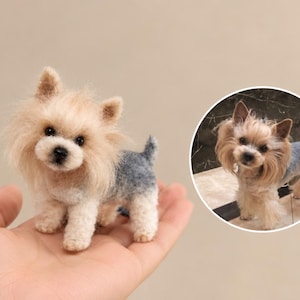 May include: A miniature needle-felted Yorkshire Terrier figurine with tan fur on the head and a grey and white body, displayed alongside a circular inset photograph of a real Yorkshire Terrier with similar colouring and long facial hair.