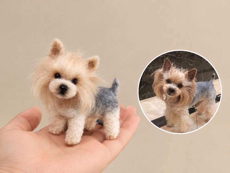 May include: A miniature needle-felted Yorkshire Terrier figurine with tan fur on the head and a grey and white body, displayed alongside a circular inset photograph of a real Yorkshire Terrier with similar colouring and long facial hair.