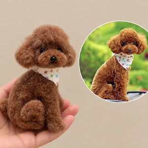 May include: A small, brown, curly-haired toy poodle figurine with a white bandana featuring a colourful, repeating geometric pattern. The figurine is shown in a circular inset image alongside a real dog wearing the same bandana.