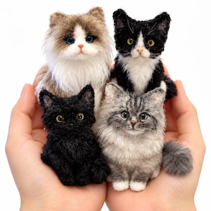 May include: Four miniature needle-felted cat figurines with realistic features. One is a long-haired brown and white cat with blue eyes, one is black and white, one is solid black, and one is a grey tabby with white paws.