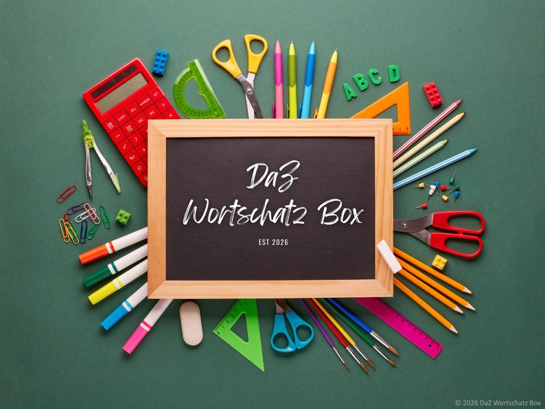 May include: A collection of school supplies arranged on a green surface. A wooden-framed chalkboard with the text "Da3 Wortschatz Box" is surrounded by pencils, pens, scissors, a calculator, and other stationery items. The text "EST 2026" is also visible.