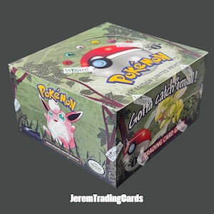 May include: A sealed Pokémon trading card game booster box featuring a green jungle-themed background, the Pokémon logo, and an illustration of Jigglypuff. The box displays the text 1st Edition Limited Printing and Gotta catch em all!