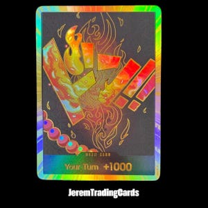 Puede incluir: Una tarjeta coleccionable rectangular con fondo negro que presenta un diseño de llamas holográficas y formas geométricas en naranja, amarillo y rojo. La sección inferior muestra el texto dorado Your Turn +1000 sobre un borde holográfico.