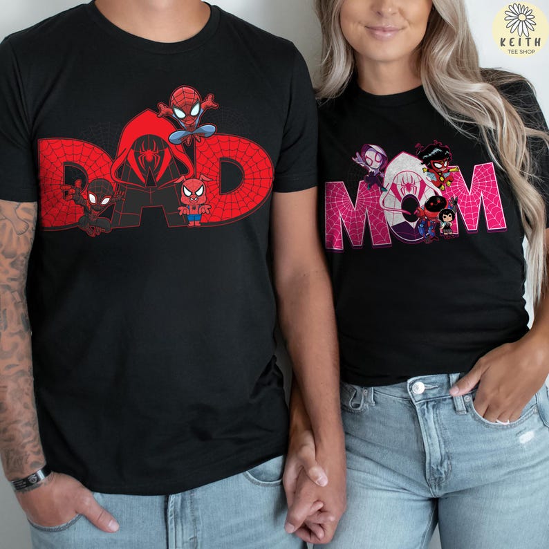 May include: Black t-shirts with Spider-Man graphics. One shirt features the word "DAD" in red with Spider-Man characters. The other shirt displays "MOM" in pink, also with Spider-Man characters. Both shirts are worn by people.