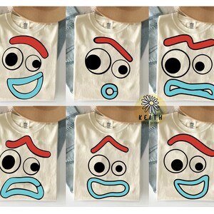 May include: Cream-colored t-shirts with various cartoon face designs. Each shirt features a different expression with black eyes, red eyebrows, and blue mouths. The text "KEITH TEE SHOP" is visible.