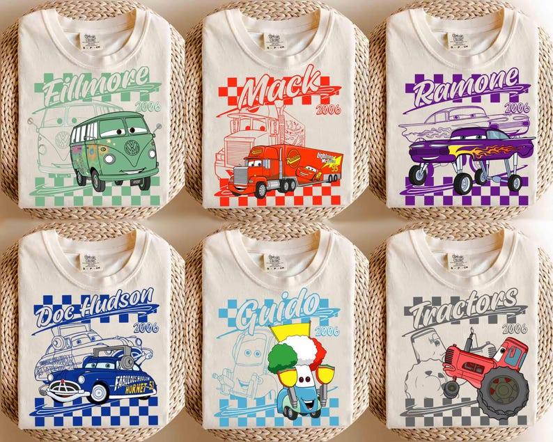 May include: Six off-white t-shirts with cartoon car graphics. Each shirt features a different character: Fillmore, Mack, Ramone, Doc Hudson, Guido, and Tractors. The designs include the character's name and the year 2006, set against a checkered background.