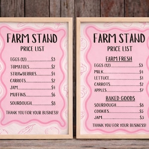 May include: Two framed pink farm stand price lists with a light wood frame. The text includes "Farm Stand", "Price List", and various items like eggs, tomatoes, and baked goods. The signs are on a wooden background.