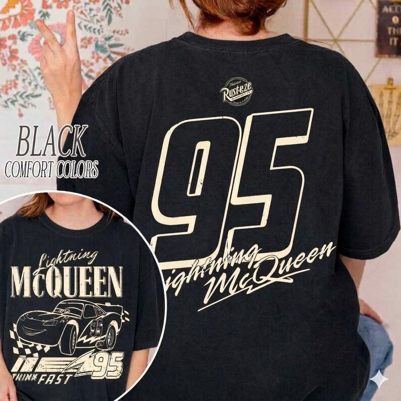 Op de afbeelding: Zwart T-shirt met het nummer 95 in grote letters op de rug. De voorkant toont een afbeelding van Lightning McQueen en de tekst "Lightning McQueen" en "Think Fast".