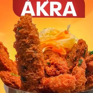 May include: A close-up of a bowl filled with golden-brown, fried food, possibly fritters or croquettes. The food has a textured, crispy appearance and is garnished with green herbs. The image includes text that reads "Potoprens AKRA" in white letters on a red background.