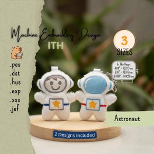 May include: Two white plush astronaut keychains with embroidered details, including a yellow star on the chest. One has a grey helmet trim, the other blue. Text includes Machine Embroidery Design, ITH, 3 SIZES, 2 Designs Included, and 4x4, 5x7, 6x10 inches.