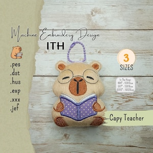 May include: A machine embroidery design file for a plush capybara character reading a book. The design features a tan capybara with brown accents, wearing glasses and holding a purple polka-dot book. Includes file formats .pes, .dst, .hus, .exp, .xxx, .jef and three sizes: 4x4 inches, 5x7 inches, and 6x10 inches.