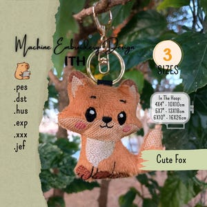 May include: An embroidered fox keyring featuring a gold-tone metal lobster clasp and ring. The fox has orange fur, black eyes, a white chest patch, and pink cheeks. Text includes Machine Embroidery Design, ITH, 3 SIZES, Cute Fox, and file formats .pes, .dst, .hus, .exp, .xxx, .jef, with hoop sizes 10x10cm, 13x18cm, and 16x26cm.