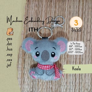 Puede incluir: Un llavero de koala de peluche gris con ojos negros bordados, nariz gris oscuro y orejas rosadas. El koala lleva una bufanda de cuadros rojos y blancos. Incluye un llavero de metal plateado y un cierre de mosquetón. Texto: Machine Embroidery Design.