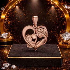 Peut inclure: Pendentif en or rose repr&eacute;sentant une m&egrave;re et son enfant dans un c&oelig;ur. Le pendentif est orn&eacute; de petits diamants scintillants et est suspendu &agrave; une b&eacute;li&egrave;re assortie. Le design est pr&eacute;sent&eacute; sur une surface en velours noir.