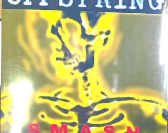 Puede incluir: Una portada de disco de vinilo cuadrada con el nombre de la banda OFFSPRING en texto blanco en la parte superior y la palabra SMASH en texto rojo en la parte inferior. El gráfico central es una silueta de esqueleto amarilla brillante y borrosa.