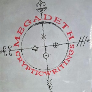 Può includere: Una copertina quadrata per disco in vinile con sfondo grigio chiaro e un emblema circolare nero centrale contenente vari simboli. Il testo rosso MEGADETH è arcuato sopra il cerchio e CRYPTIC WRITINGS è arcuato sotto in lettere rosse.