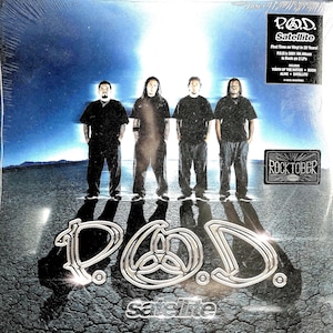 May include: A vinyl record cover for the P.O.D. album Satellite, featuring four individuals standing on a cracked desert floor under a bright blue sky. The silver P.O.D. logo is prominent at the bottom, with a black sticker detailing the 20th anniversary release and a Rocktober sticker.