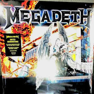 May include: A vinyl record cover for Megadeth's United Abominations featuring a winged figure amidst explosions and fire. A black sticker on the left displays the text: Megadeth United Abominations, The classic album back on vinyl, 180g black vinyl.