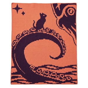 May include: A rectangular crochet blanket featuring a two-tone design in peach and dark purple. The pattern depicts a dark purple octopus tentacle curving upward with a small cat silhouette sitting on top, accompanied by two four-pointed stars.