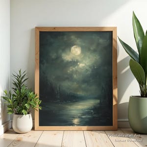 May include: A framed landscape painting depicts a moonlit night scene over a body of water. The artwork, in shades of teal, gray, and white, is set in a natural wood frame. The text "Printable Wall Art Instant Download" is visible in the lower right corner.