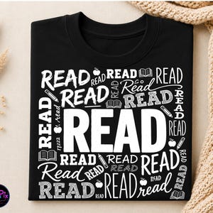 Peut inclure: Un sweat-shirt noir à col rond avec un motif graphique blanc composé du mot READ répété dans diverses polices et tailles, entremêlé de petites illustrations de livres ouverts, de crayons et de pommes sur tout l'imprimé.
