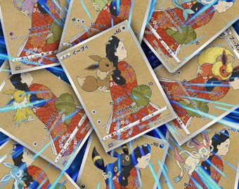 Könnte beinhalten: Eine Sammlung von Sammelkarten mit einer Frau in einem roten Kimono, die verschiedene Cartoon-Kreaturen hält. Die Karten haben japanischen Text und sind vor einem hellbraunen Hintergrund mit blauen Streifen angeordnet.