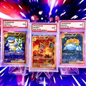 Può includere: Tre carte del gioco Pokémon del 1999 in custodie protettive. Le carte presentano Blastoise EX, Charizard EX e Venusaur EX. Ogni carta è classificata GEM MT 10 ed etichettata come Special Art Rare.