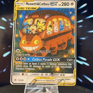 K&ouml;nnte beinhalten: Eine Sammelkarte mit einem Cartoon-Katzenbus und verschiedenen Cartoon-Charakteren. Die Karte tr&auml;gt die Aufschrift "Meowth&Catbus GX" und "Catbus Parade GX". Die Karte wird auf einem transparenten Kunststoffst&auml;nder pr&auml;sentiert.