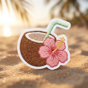 May include: An embroidered patch featuring a brown coconut with a light tan interior, a light green straw, and a pink hibiscus flower with a yellow center. The design has a white border and is shaped to follow the contours of the coconut and flower.