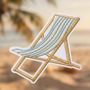 May include: An embroidered patch shaped like a beach chair with a gold frame and light blue and white striped fabric. The design features a white border and detailed stitching that outlines the structure of the folding chair.