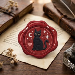 May include: A circular, deep red wax seal-style patch featuring an embroidered black cat sitting in the center. The design includes a white crescent moon, a pink heart, and white starburst accents against the dark red background.
